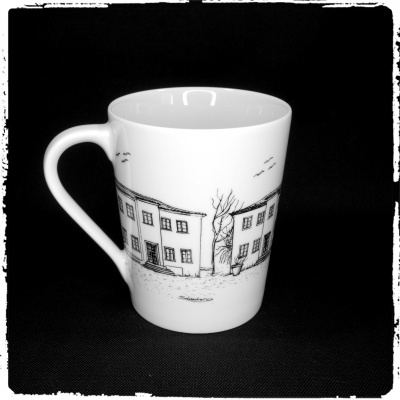 Caneca branca com desenho preto de casas e árvore