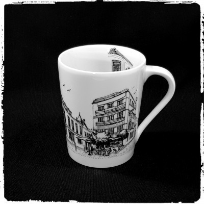 Caneca branca com desenho preto de edifícios e pessoas