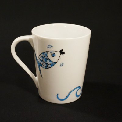 Caneca branca com desenho de peixe azul e onda
