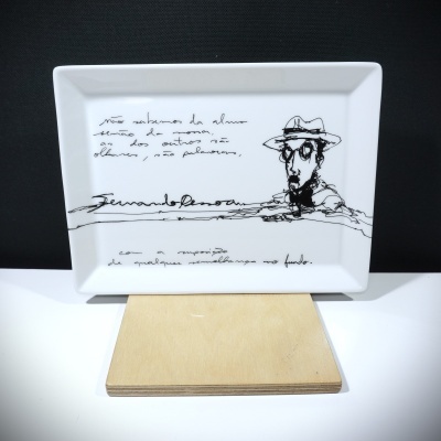 Prato branco retangular com desenho e texto em preto, figura com chapéu e óculos e texto manuscrito