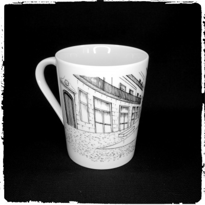 Caneca branca com desenho de edifícios em preto sobre fundo preto