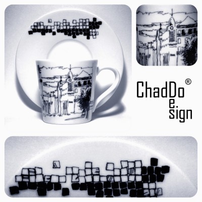 Xícara e pires de porcelana branca com desenhos pretos de edifícios e quadrados