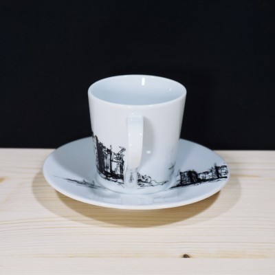 Chávena de porcelana branca com desenhos arquitetónicos e pires em madeira clara