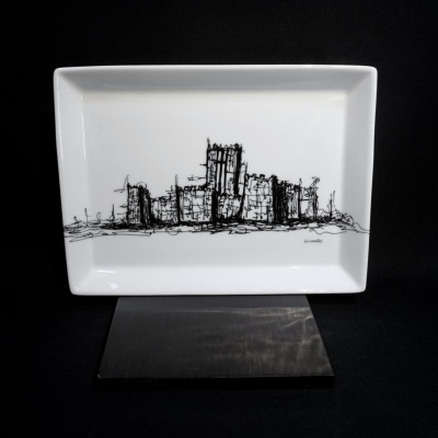 Prato cerâmico branco com desenho a tinta preta de um castelo, assinado Guimarães