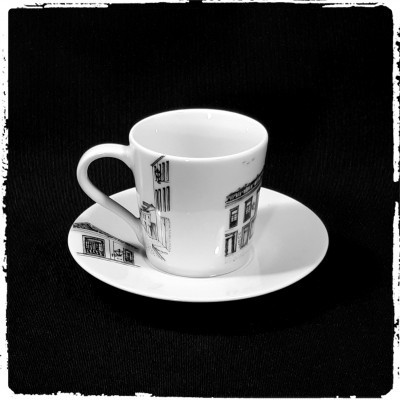 chávena e pires brancos com desenhos de edifícios pretos