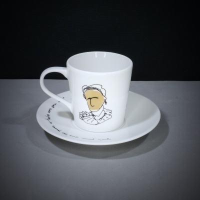 Chávena de cerâmica branca com desenho minimalista e prato com texto manuscrito