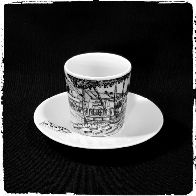 Chávena de porcelana branca com desenho preto e pires branco com decoração