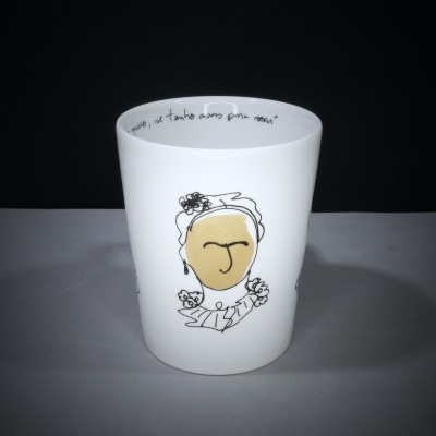 Copo branco com rosto artístico e texto manuscrito na borda interior