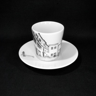 Conjunto de chávena e pires em cerâmica branca com desenho a preto