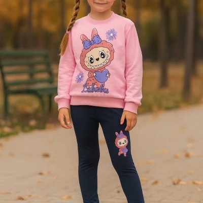 Roupa infantil rosa e preta com personagem Labubu e ténis cor-de-rosa em parque de outono