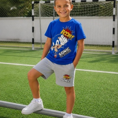 Criança com conjunto azul e cinzento do Sonic no campo de futebol