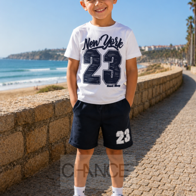 Menino com roupa casual branca e preta numa passeata junto à praia sob céu azul claro