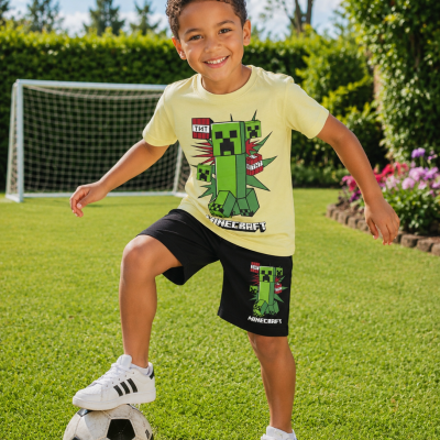 Menino em roupa Minecraft joga futebol no relvado com baliza ao fundo