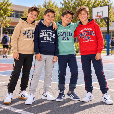 Quatro rapazes com sweats com capuz coloridas e calças desportivas em campo de basquetebol.