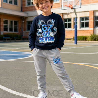 Conjunto infantil sweat-shirt azul escuro e calças cinza claro com estampados, em campo de basquetebol.