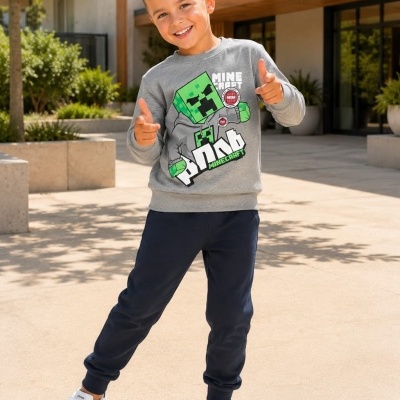 Camisola cinzenta com estampado Minecraft, calças azuis e ténis brancos Adidas em cenário exterior