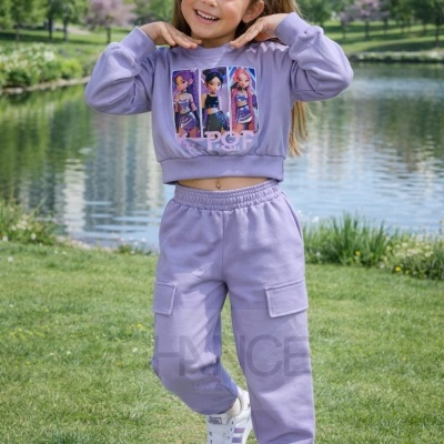 Menina vestindo conjunto desportivo lilás com estampa de personagens, posando ao ar livre junto a lago e prédios.
