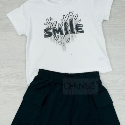 Conjunto infantil com t-shirt branca estampada e calções pretos.
