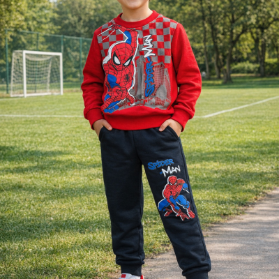 Menino com roupa desportiva vermelha e preta com estampados Spider-Man em campo de futebol