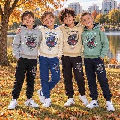 Quatro rapazes com roupas de capuz e calças estampadas com dinossauros em parque outonal.