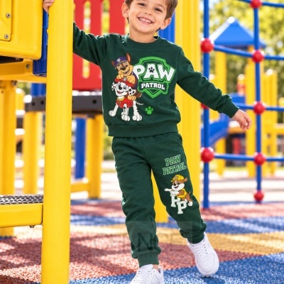 Menino no parque com fato de treino verde PAW PATROL e sapatilhas brancas