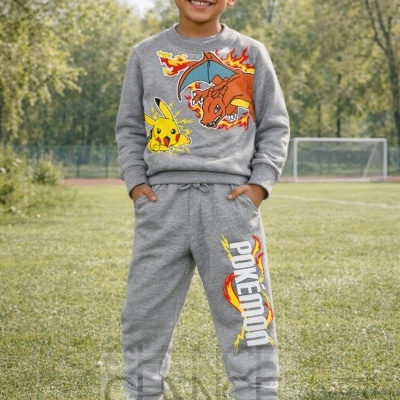 Menino com conjunto cinzento Pokémon num campo verde com rede de futebol