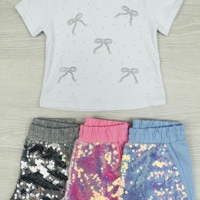 Conjunto de t-shirt branca com laços brilhantes e três calções de lantejoulas cinzento, rosa e azul