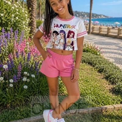 Menina com crop top anime HUNTRIX, calções rosa e ténis brancos e rosa em jardim e praia