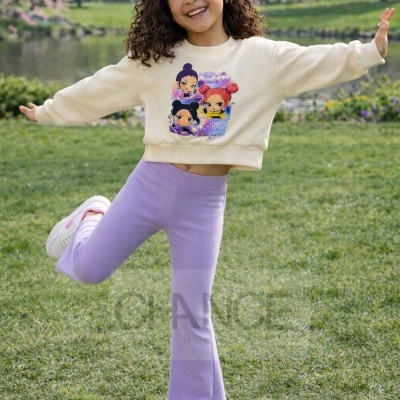 Menina com sweatshirt estampada e calças lilás num parque verde