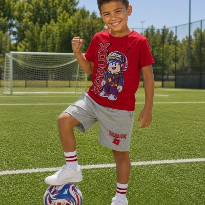 Rapaz em campo de futebol com camisola vermelha e calções cinzentos Roblox