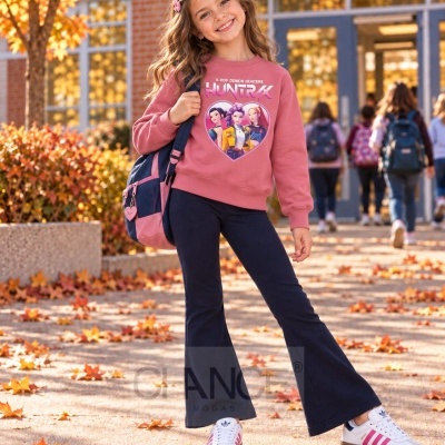 Menina com sweatshirt rosa estampada com personagens de K-pop, calças pretas e mochila azul cor de rosa em ambiente escolar no outono