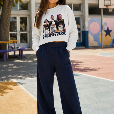 Criança com sweatshirt branca HUNTRAX e calças largas azul escuro no campo de basquetebol