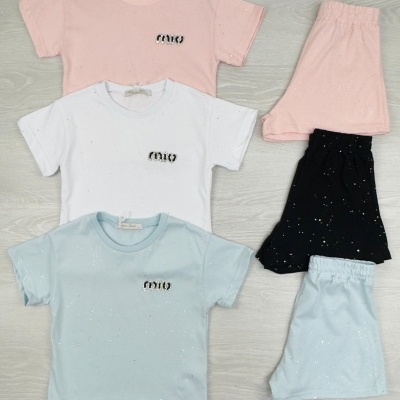 Roupas de criança: t-shirts rosa, branca, azul claro e calções rosa, preto, azul claro com logo 'mio'.