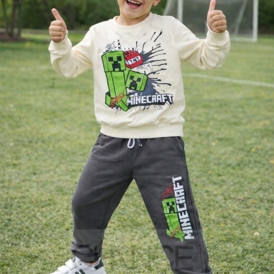 Menino alegre em roupa com estampado Minecraft no campo de futebol