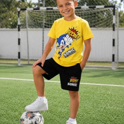 Camisola amarela e calções pretos de criança com desenho do Sonic the Hedgehog em campo de futebol.