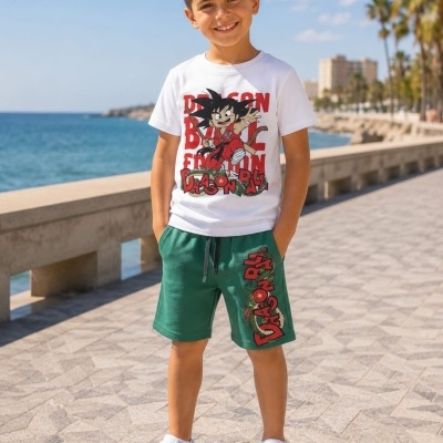 Rapaz criança com conjunto de roupa Dragon Ball, t-shirt branca e calções verdes, ao ar livre perto do mar