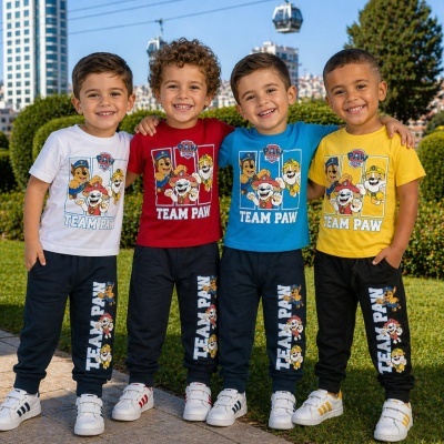 Quatro crianças vestindo conjuntos com t-shirts coloridas e calças com personagens de desenho animado Team Paw.