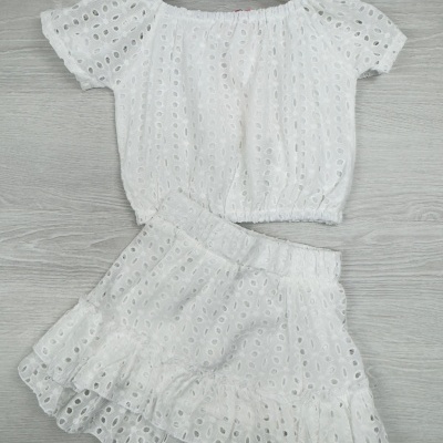 Conjunto branco de top e saia com padrão perfurado, pendurado em cabide