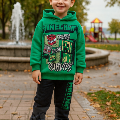 Menino com conjunto verde e preto Minecraft num parque com fonte e parque infantil ao fundo