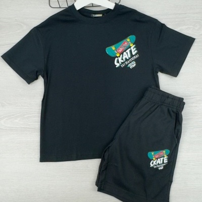 Conjunto de t-shirt e calções pretos com estampado colorido de skate e texto, t-shirt pendurada em cabide branco