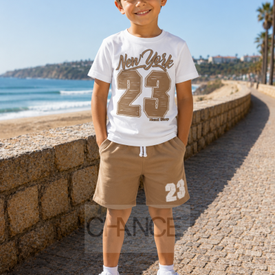 Menino com roupa casual branca e castanha junto ao mar sob céu azul