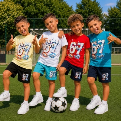 Quatro meninos com roupa desportiva colorida estampada com o número 67 e bola de futebol em campo de futebol.