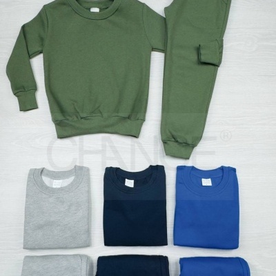 Conjunto de roupa infantil em várias cores dobrada e disposta sobre fundo claro