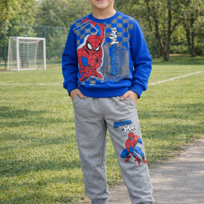 Menino com conjunto de roupa do Homem-Aranha ao ar livre num campo de futebol