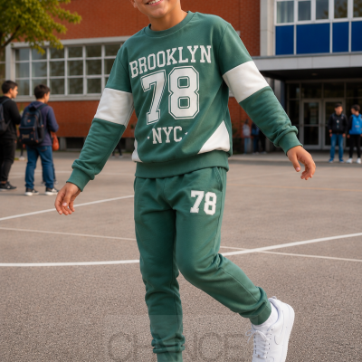 Criança com fato de treino verde e branco com texto Brooklyn 78 NYC num pátio escolar