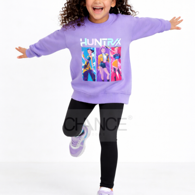 Criança com camisola lilás estampada, leggins pretas e ténis lilás e branco