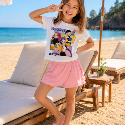 Menina na praia com t-shirt branca estampada, calções rosa e chinelos rosa