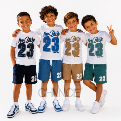 Quatro miúdos com t-shirts brancas estampadas com New York 23 Next Stop e calções coloridos posando juntos.