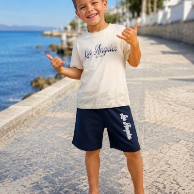 Menino sorridente com roupa casual bege e azul tirada à beira do mar