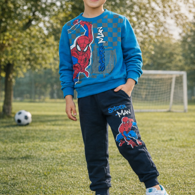 Menino com fato de treino do Homem-Aranha posando em campo de futebol